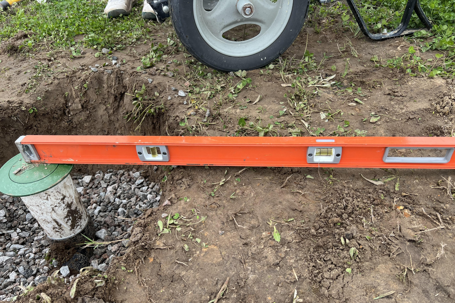 Large level sitting atop a drainage system cap.