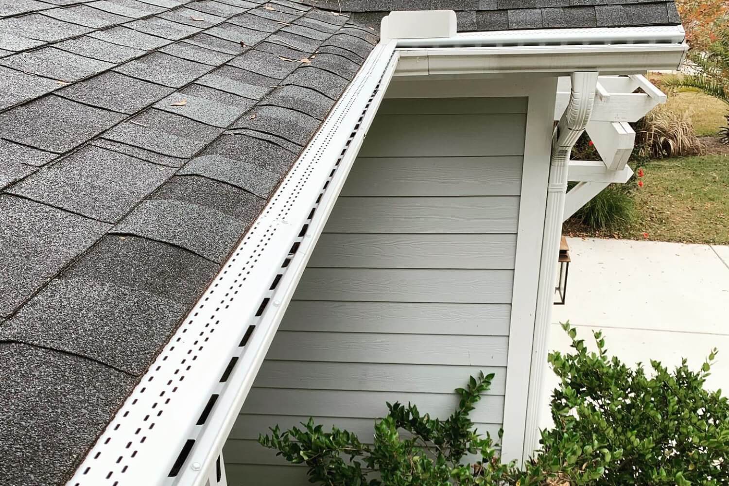 Close up of gray roof with clean white gutter guards.